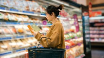 woman reading ingredients list in supermarket