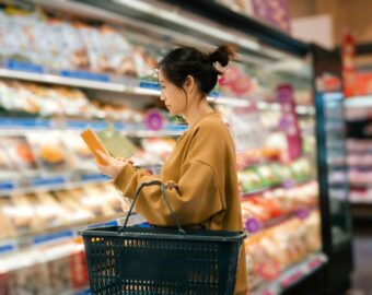 woman reading ingredients list in supermarket