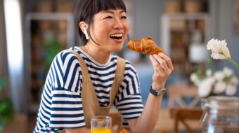 a woman eating a croissant for breakfast