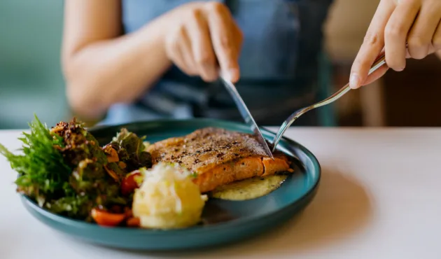 Woman eating salmon dinner