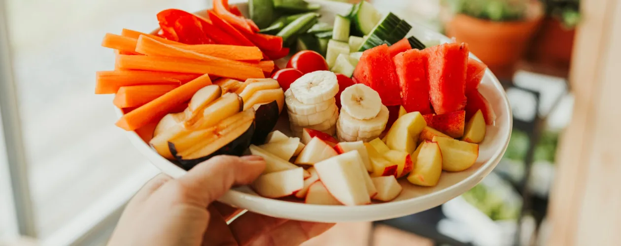 person holding colorful fruit vegetable plate
