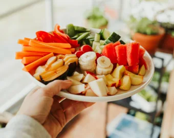 person holding colorful fruit vegetable plate
